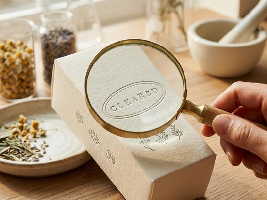 FDA cleared badge on box under magnifying glass near lab jars